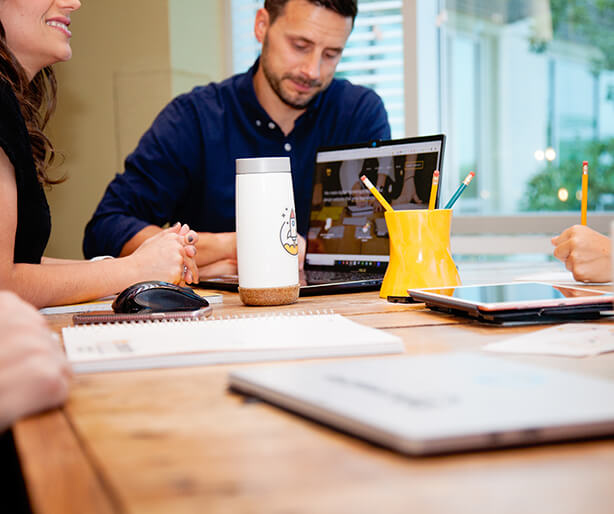 person holding phone with laptop