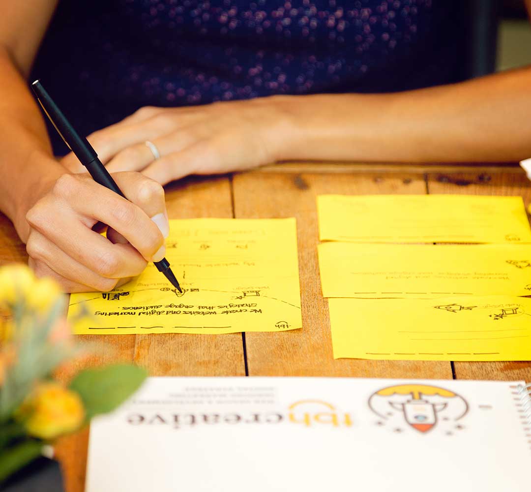 Close-up of someone sketching a website design on paper