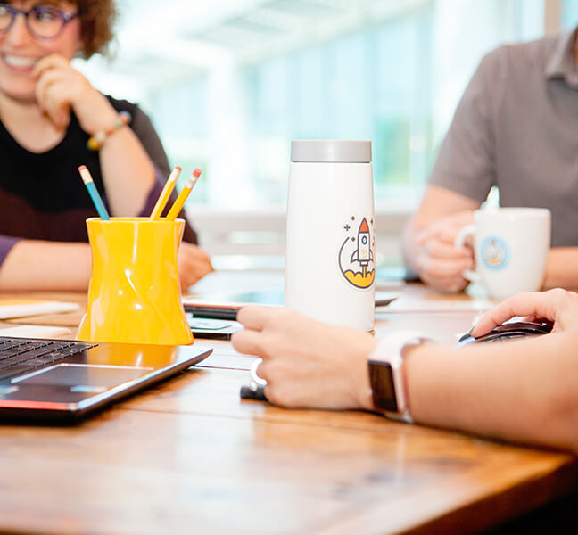 Close-up of team member using laptop in marketing meeting