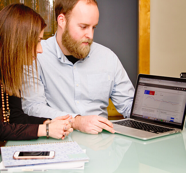 Team reviewing Google AdWords report on laptop