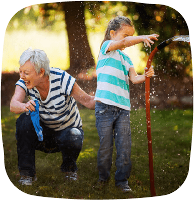 granddaughter playing with hose with grandmother