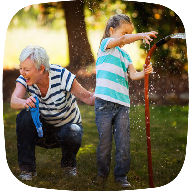 granddaughter playing with hose with grandmother