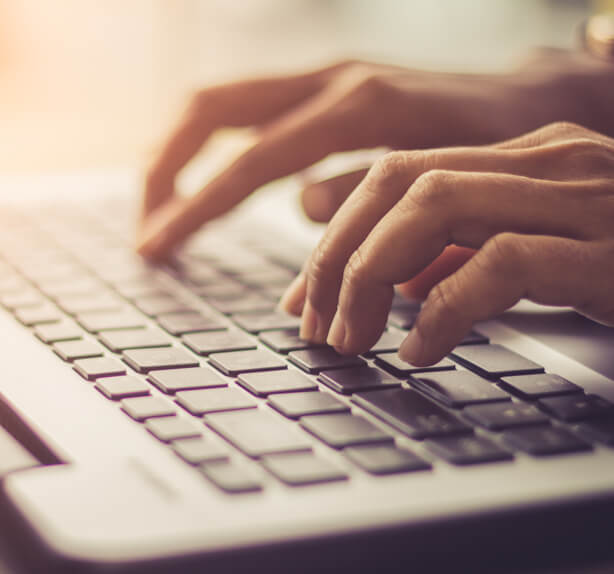 hands typing on laptop