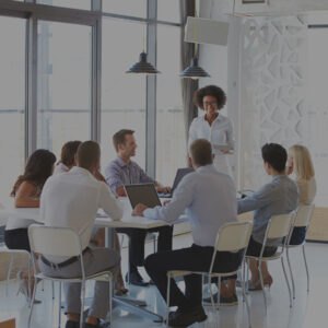 employees sitting around a table in an office meeting room