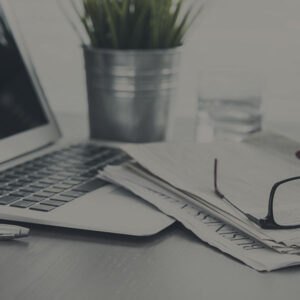 close up of office desk with laptop and papers