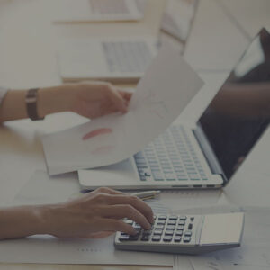 person looking at budget documents and using a calculator