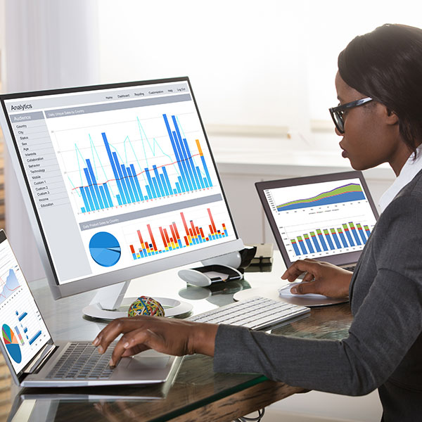 Young woman viewing multiple screens of analytics