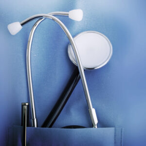 closeup of a doctor with a stethoscope in the pocket of scrubs