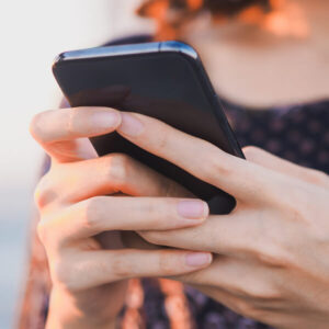 a woman using a smartphone struggles to find the right place to go because keyword cannibalization is causing her to see confusing search results on Google