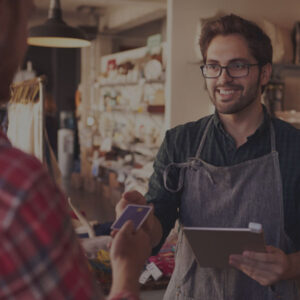 salesperson in an apron taking credit card from customer