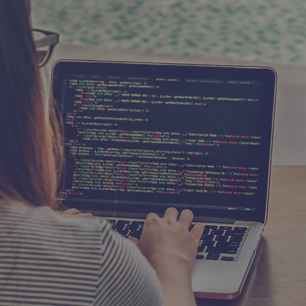 Programmer Typing New Lines of HTML Code. Laptop and Hand Closeup