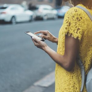 woman searching phone on street