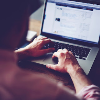 man writing content on computer