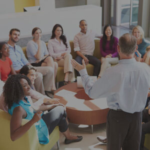 Man talking to a group of coworkers in a team meeting